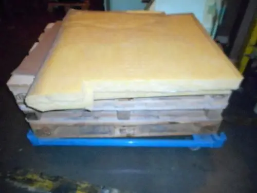 Pallet mit Isoliermaterial in gelber Farbe, platziert auf blauen Rollwagen. Teile offensichtlich für Remeha Kesselkörper, keine Maße erkennbar.